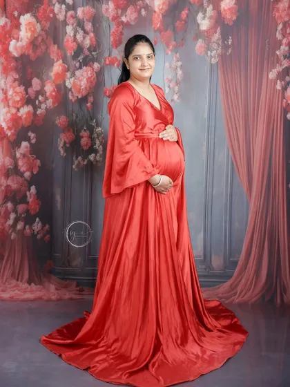 A beautiful full-length portrait of the mom-to-be in a striking red gown. The elegant draping of the fabric and the soft lighting create a timeless look.