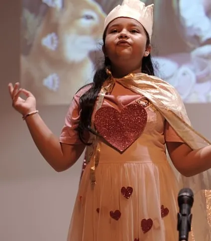 A character is more than just a costume. It's an emotion, an attitude, and a presence. This young star, portraying the Queen of Hearts, embodies the confidence and expressive power we cultivate in every child during our stage productions.