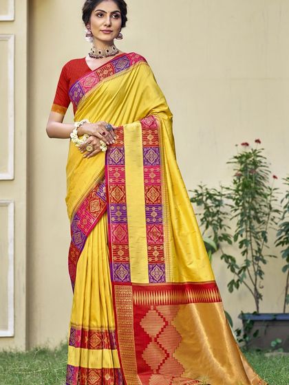 A vibrant yellow Dupion silk saree with a contrasting red border. This traditional saree is perfect for bringing a ray of sunshine to any celebration.