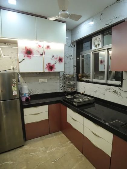 Even a small kitchen can be highly functional and stylish. This L-shaped kitchen uses profile shutters, digital glass, and a compact layout to make the most of the available space.