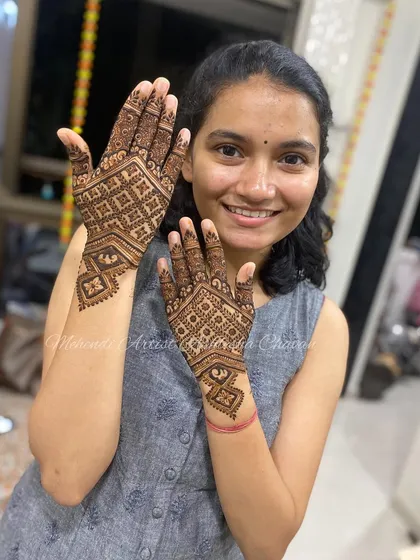 A happy client with her geometric back-of-hand design. The checkerboard pattern is modern and stylish, perfect for a contemporary look.