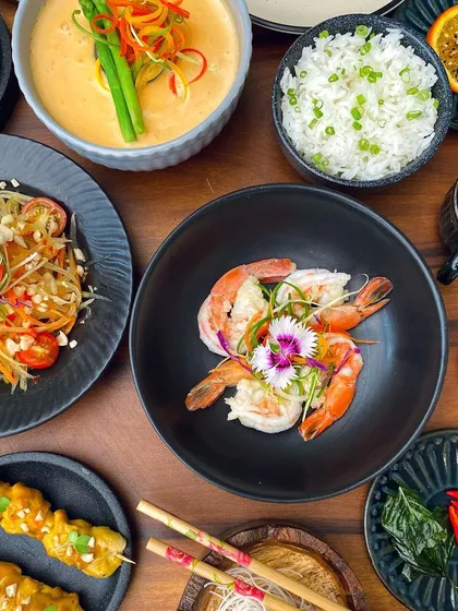A beautiful flat lay of our Thai feast, featuring prawns, satay, and Som Tam salad, capturing the essence of Southeast Asian cuisine.