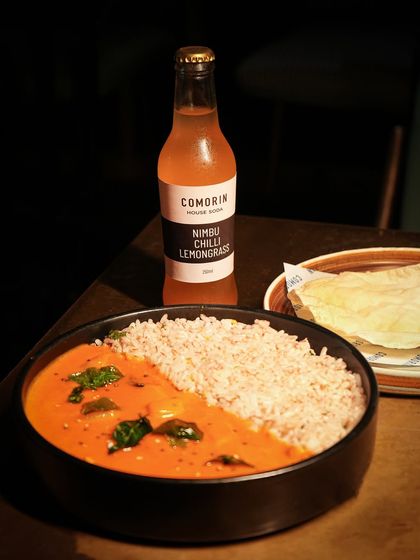 A taste of home, our Kerala-style meen curry is spicy, tangy, and full of warmth. We serve it with nutritious red rice and a crisp papad, perfectly paired with our house-made Nimbu Chilli Lemongrass soda.