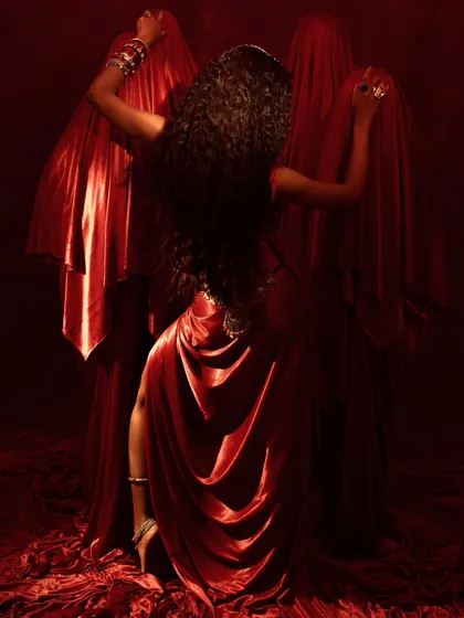 A back-facing shot that creates a dynamic, dance-like pose. It highlights the model's long, flowing hair and the way the jewelry moves with her body.