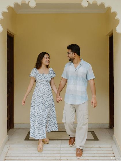 A happy, walking shot of the couple, hand-in-hand, their smiles telling the whole story.