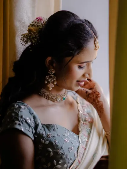 A beautiful side profile showcasing the soft hairstyle and the delicate jewellery. The makeup is all about enhancing her glow.