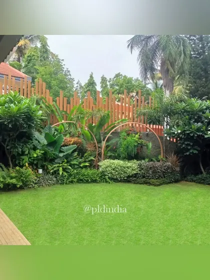 A beautiful lawn in a Juhu residence, framed by a sculptural fence and layered tropical planting. This space serves as a green heart for the property, providing a soft, open area for relaxation and play.