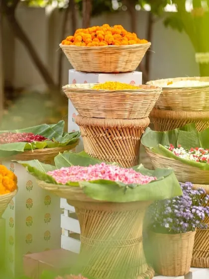 A beautiful display of fresh flower petals and marigold laddus in rustic baskets, ready for traditional rituals and celebrations.