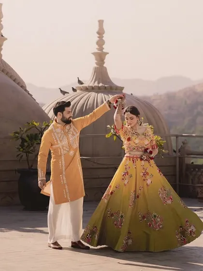 A dance against the skyline. This shot captures the fun and festive spirit of a pre-wedding celebration, with the bride's lehenga creating a beautiful silhouette.