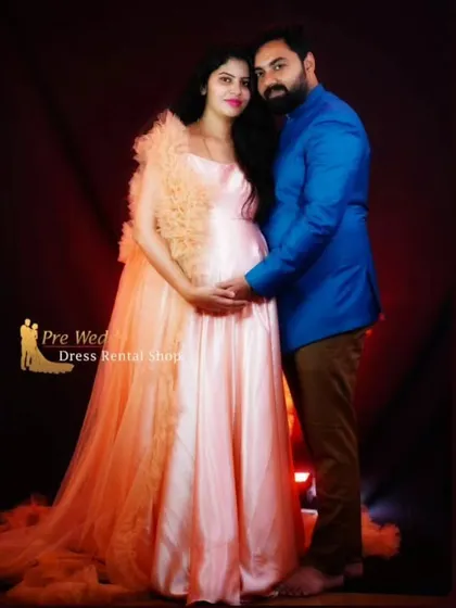 A classic studio portrait of a couple, with the expecting mother in our elegant peach satin gown. The ruffled shrug adds a touch of texture and sophistication to this timeless maternity look.