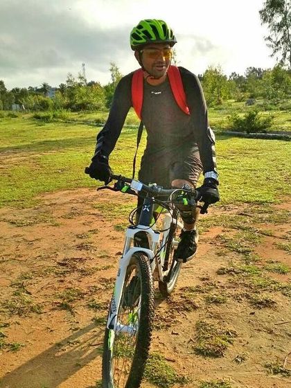 A cyclist navigating a grassy, uneven path on a mountain bike during one of our weekend explorations.