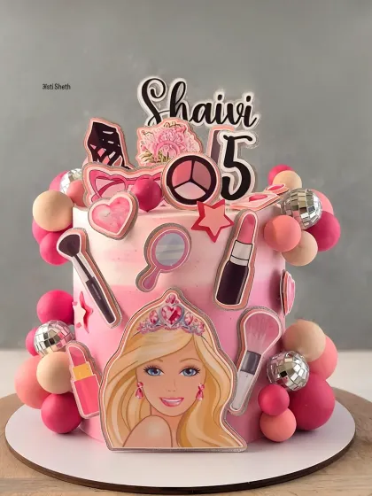 A glamorous Barbie and makeup themed cake for a 5th birthday. This pink ombre cake is decorated with edible images of makeup items and a Barbie princess.