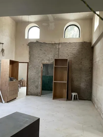 This is a space in transition. The original mitti walls are exposed, and the arched windows hint at the building's heritage. Empty shelves wait to be filled with stories. This is the quiet potential I look for in every project.