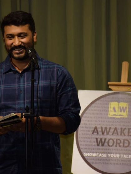 A performer sharing his writing at an "Awaken Words" open mic, happy to bring his words to life.
