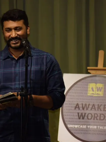 A performer sharing his writing at an "Awaken Words" open mic, happy to bring his words to life.