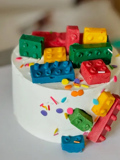 Building a dream cake, one edible block at a time. This LEGO-themed creation is a kid's fantasy, made entirely with whipped cream and colorful, hand-molded chocolate blocks.