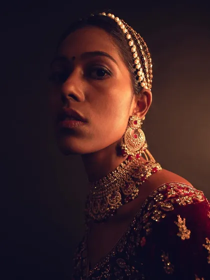 This is a look from a high-fashion ethnic couture shoot. I focused on creating a luminous, glowing effect on the model's beautiful dusky skin, using subtle contouring and highlighting to accentuate her features under dramatic lighting. The makeup was designed to complement the rich velvet lehenga without overpowering it.