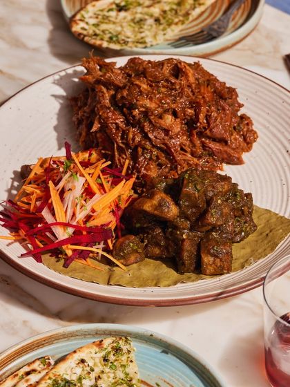 Our slow-cooked Raan Musallam, pulled and ready to be shared. This dish is perfect for large gatherings, offering a rich, flavorful centerpiece that guests can enjoy together.