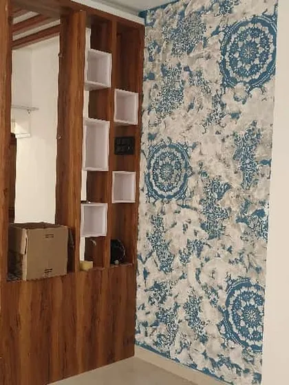 A custom mandala stencil design can beautifully complement your home's interior elements. Here, a blue and white pattern creates a striking accent wall next to a wooden partition, adding a touch of traditional art.