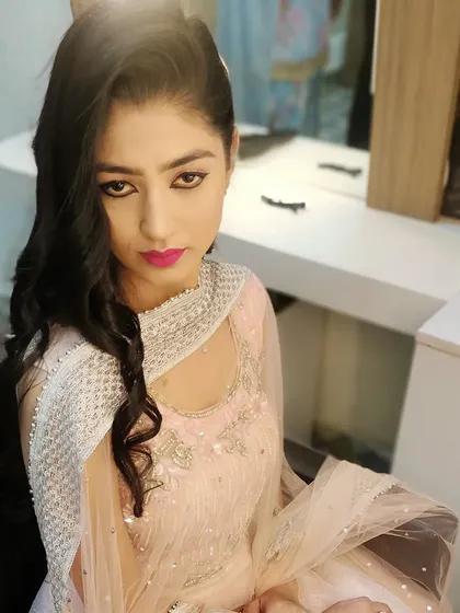 A soft and pretty party makeup look. For this client, we chose a bright pink lip and defined eyes to complement her light pink and silver outfit, making her ready for a daytime function or festive gathering.