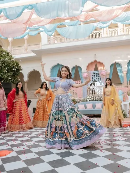 The bride and her squad in the middle of a fun, choreographed routine at her Mehendi. The colorful outfits and outdoor setting create a picture-perfect moment.