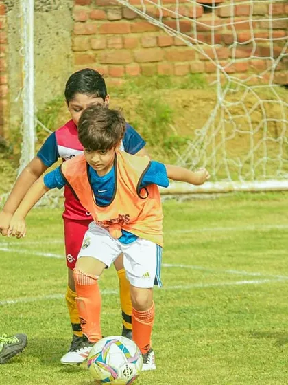 Our players battling for possession during a U8 Pride Cup match. We teach them to be strong and confident on the ball.