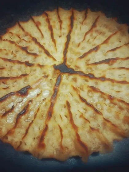 This is Khoba Roti, a traditional Rajasthani bread known for its distinctive pinched design. It's cooked over an open fire to get that authentic, smoky flavour and rustic texture.