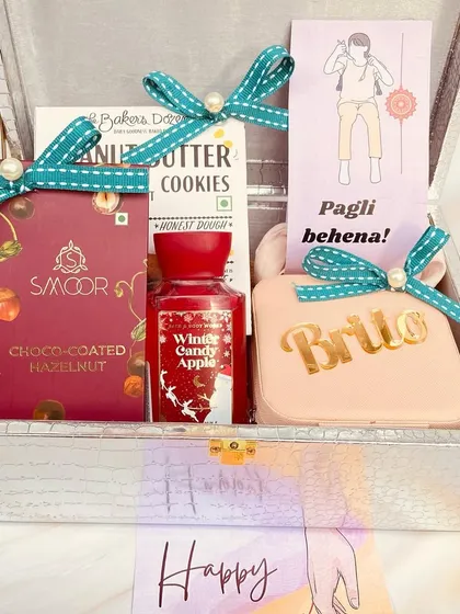Inside the trunk box for the 'pagli behena' (crazy sister). This hamper includes a personalized case, cookies, and body care, all tied with cute ribbons.