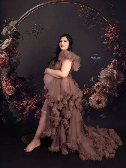 This is another one of my gorgeous rental gowns, this time in a lovely brown tulle. The dark, moody floral backdrop in the studio creates a very artistic and dramatic maternity portrait.