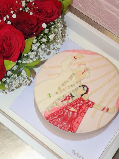 Our wedding illustration cake, pictured with a bouquet of red roses, ready to be the centerpiece of an anniversary or engagement celebration.