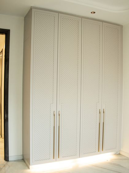 This custom-designed wardrobe fits perfectly into the space, with a subtle texture that elevates the room's aesthetic.