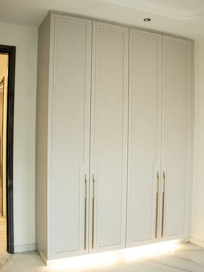 This custom-designed wardrobe fits perfectly into the space, with a subtle texture that elevates the room's aesthetic.