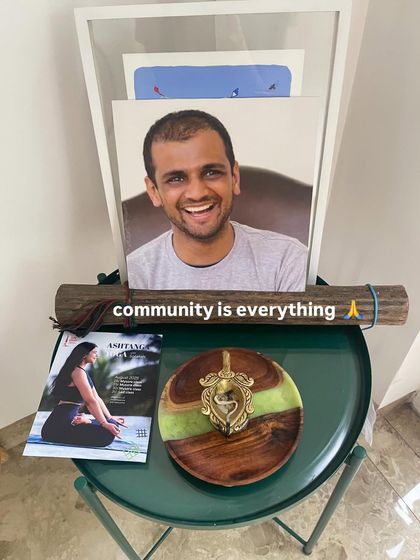 A small altar reminding us that community is everything. A photo of my Guru, a magazine feature, and a sacred symbol all represent the journey and the people who are part of it.