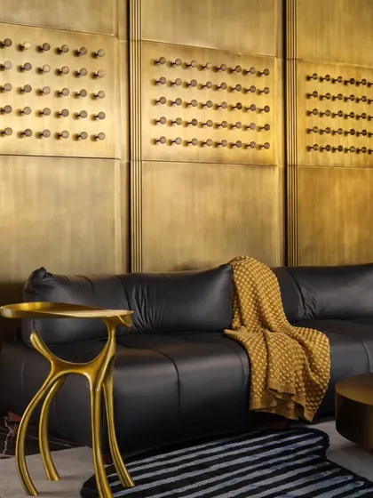 Detail of the brass wall paneling and custom side table. The intricate patterns on the wall and the sculptural form of the table show my commitment to detail, where every element is chosen to contribute to the overall story of the space.