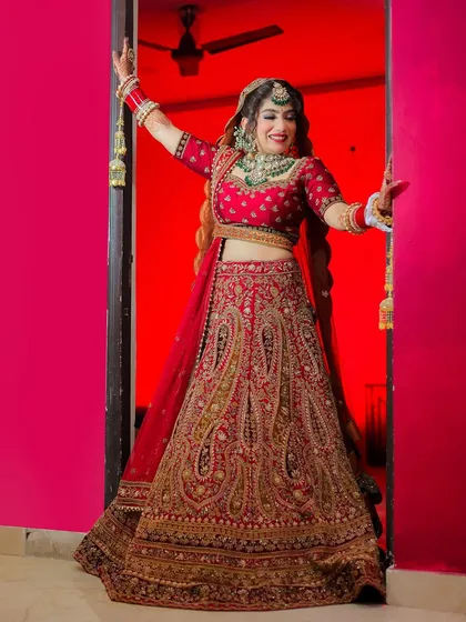 A fun and dynamic full-length portrait of a bride in a doorway, framed by a vibrant pink wall.