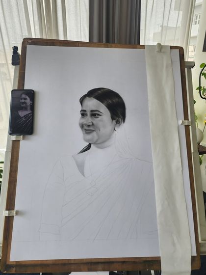 A work-in-progress shot of the A1 portrait, with the reference photo visible on my phone for comparison.