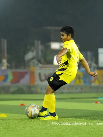 A young player strikes the ball with proper technique during a shooting drill.