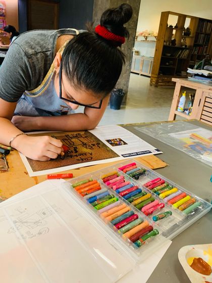 A student uses oil pastels to add texture and detail to her artwork, a technique often explored in our Picasso workshops.