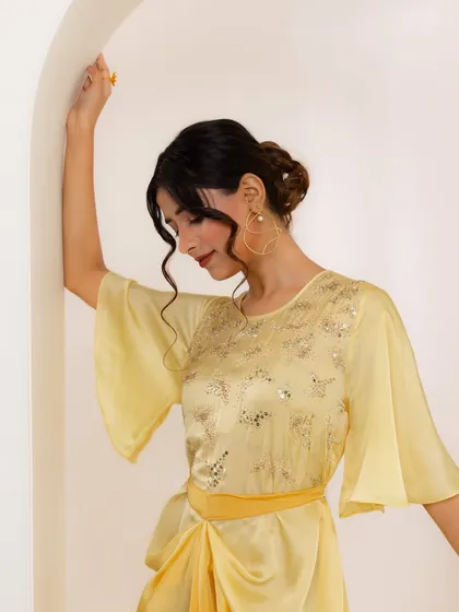 A final look at the yellow dress, focusing on the soft, draped fabric and elegant movement.