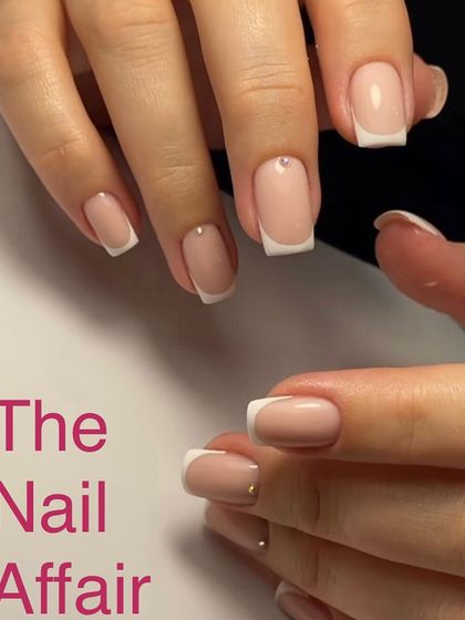 A sharp, classic French manicure on square-shaped nails, accented with a single tiny rhinestone at the base for a touch of subtle sparkle.