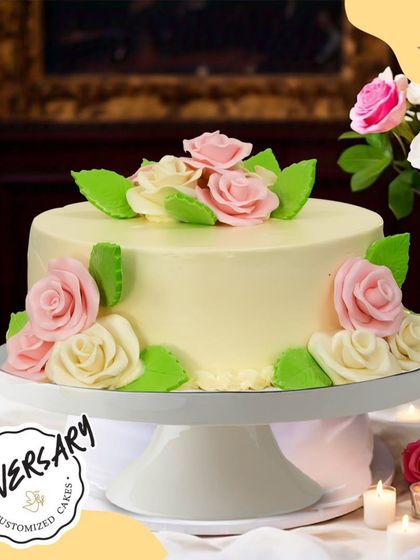 A sweet and classic floral cake for Mr. and Mrs. Rawat's anniversary in Jor Bagh. The cake is decorated with soft pink and white buttercream roses, creating a simple and romantic feel.
