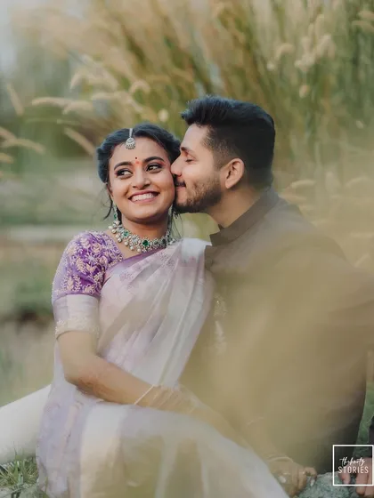 A sweet and playful moment during a golden hour shoot. The groom's gentle kiss on her cheek and her bright smile create a feeling of pure happiness.