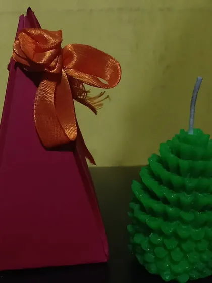 My pinecone-shaped candle, shown here with a simple gift box. These are very popular during festivals and for corporate gifting, offering a unique, nature-inspired decorative touch.