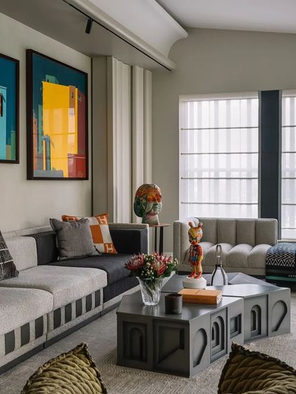 A playful and colorful living space with bold contemporary art, sculptural coffee tables, and a mix of modern and eclectic furniture.