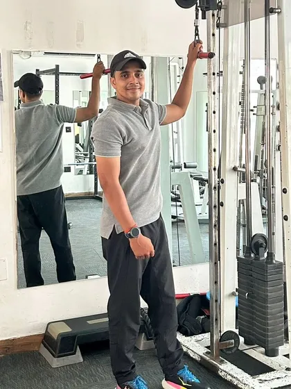 Posing by the cable machine after a set of tricep exercises.