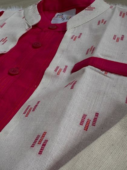 A close-up of our deep red kurta and Nehru jacket set. The texture of the woven jacket contrasts beautifully with the soft cotton kurta.