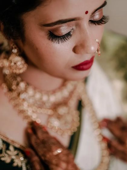 Another angle of the bride, showing her stunning makeup, long eyelashes, and the detail of her gold necklace.
