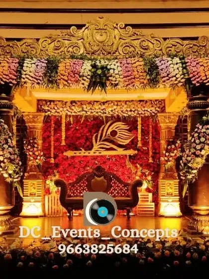 Another angle of the grand traditional wedding stage, showing the depth and detail of the backdrop. The peacock feather motif and layered florals create a rich and visually stunning focal point.