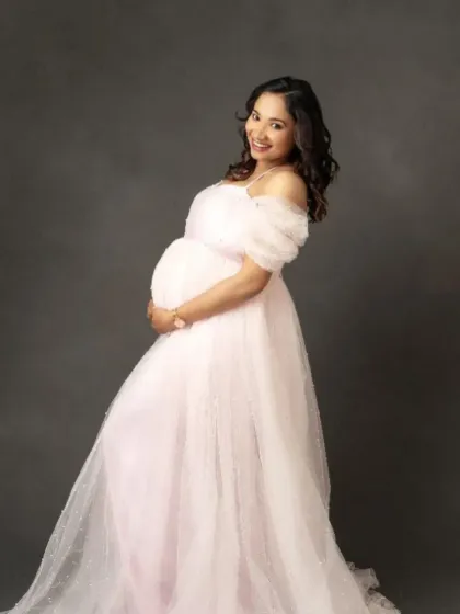 A classic portrait in our light pink off-the-shoulder tulle gown. The soft color and fabric create a gentle, ethereal glow.