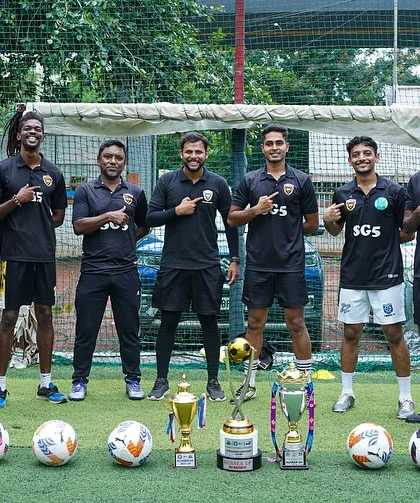 Our coaches pointing to the SG5 crest. We are one team, united in our mission to build champions.